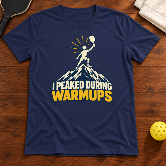 I Peaked During Warmups Pickleball T-Shirt, navy, warm wood flat lay