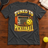 Tuned to Pickleball T-Shirt, dark-grey-heather, warm wood flat lay